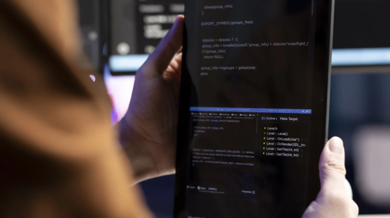 Teleworking programmer designing and developing software applications using tablet. IT administrator implementing and maintaining company systems using portable device, close up